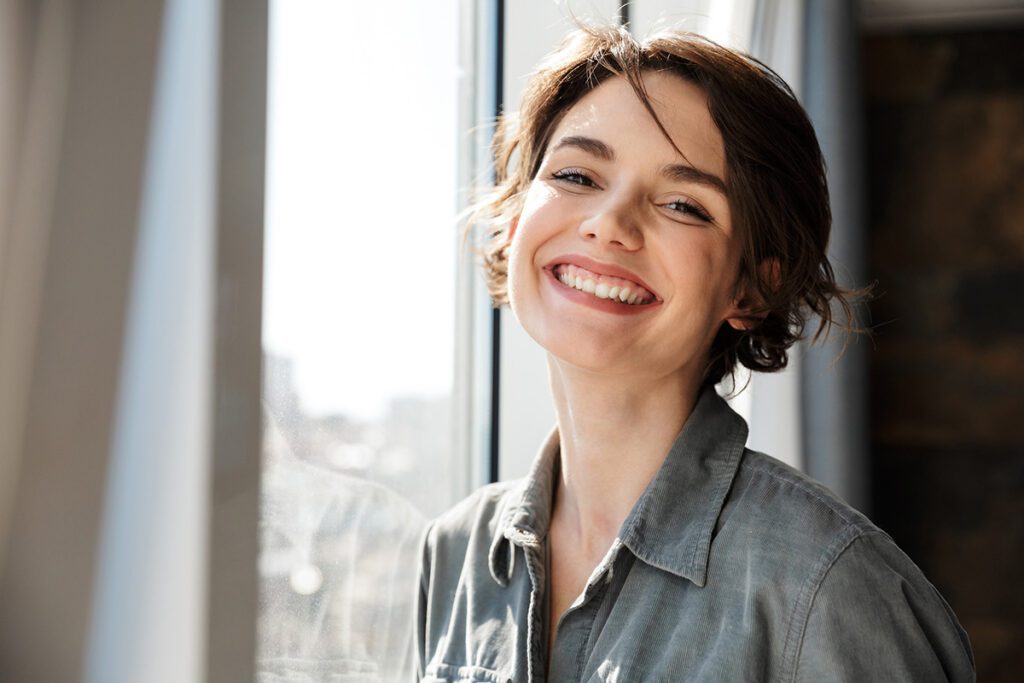Image of beautiful young joyful woman smiling