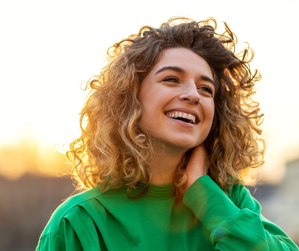 Portrait of young woman with curly hair in the city