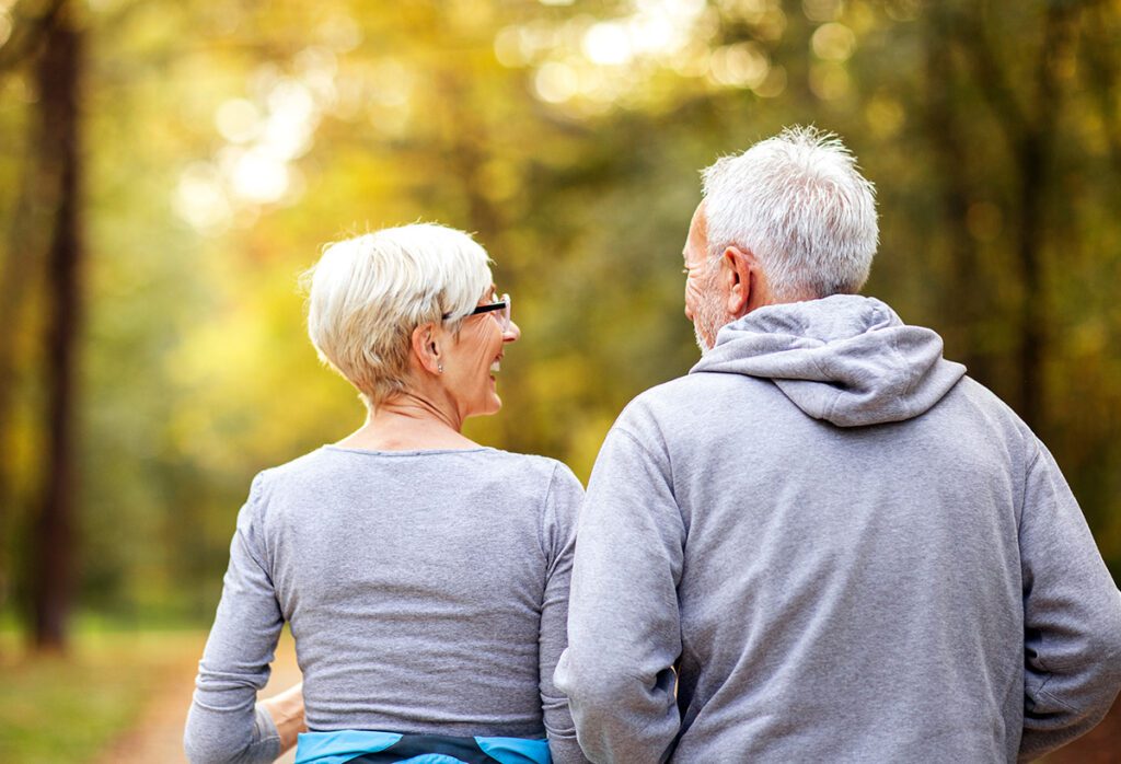 elderly couple walking in woods