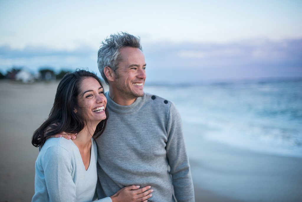 Couple smiling walking on a beach