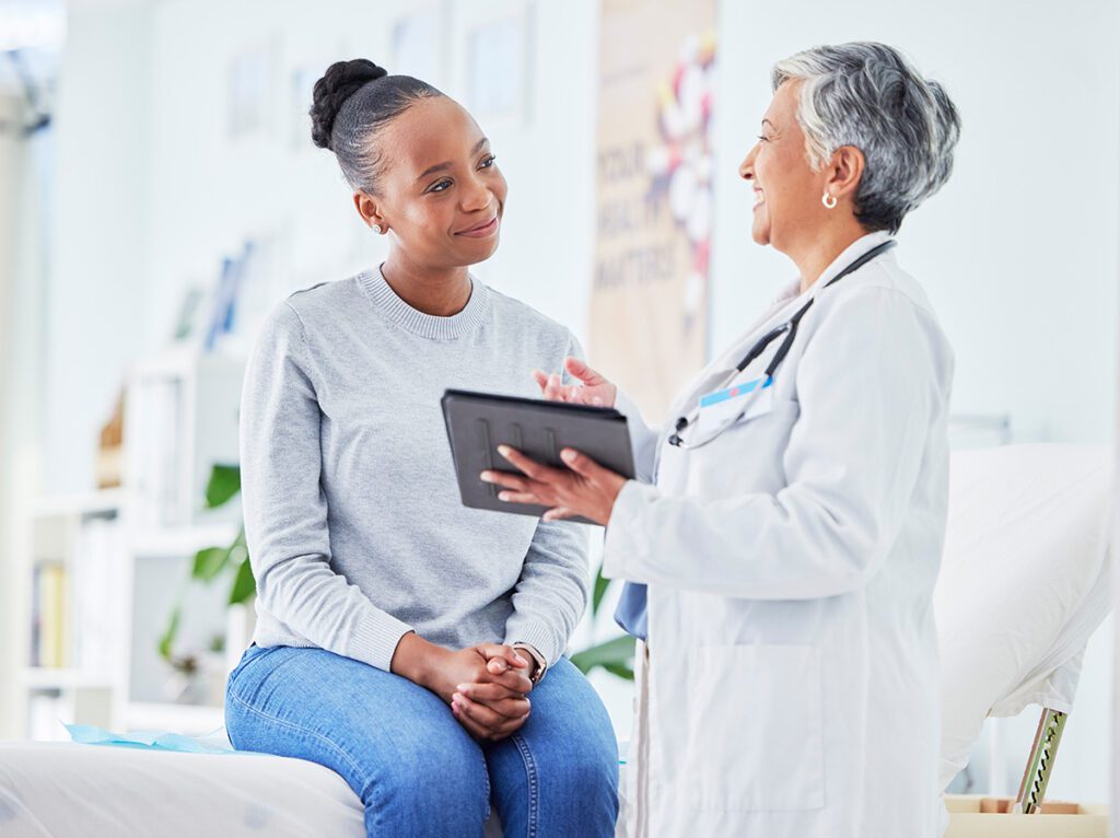 Happy women at appointment with doctor helping