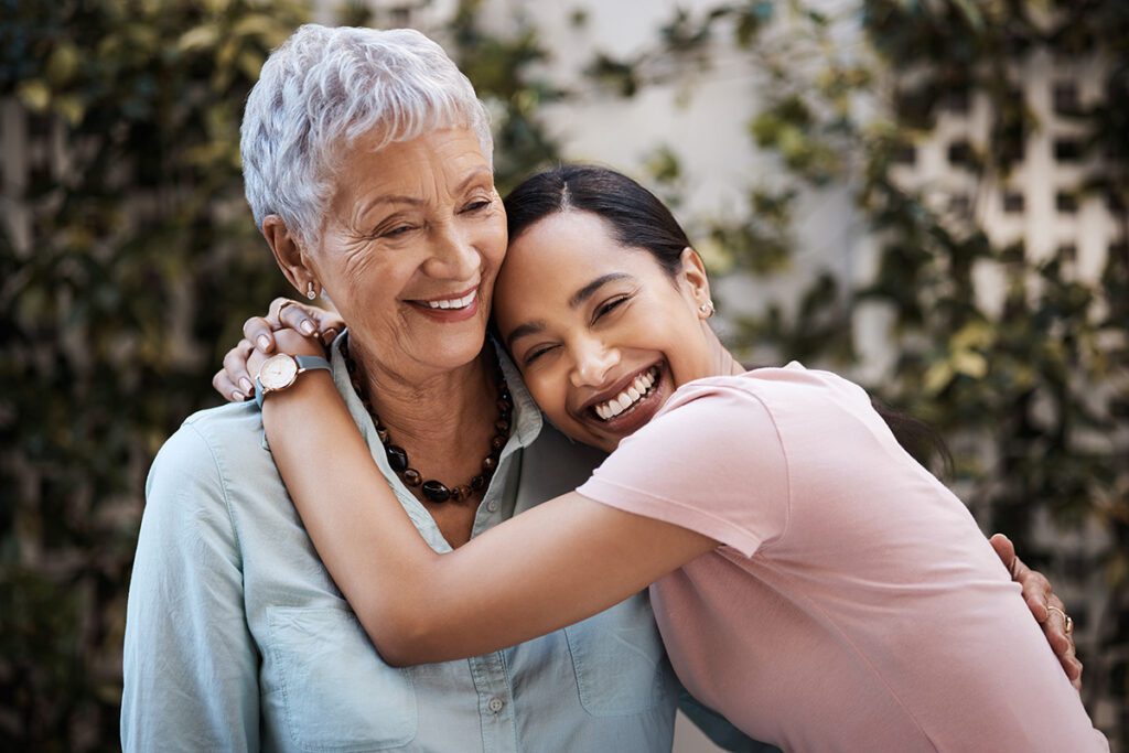 Mother and daughter hugging and smiling in the garden
