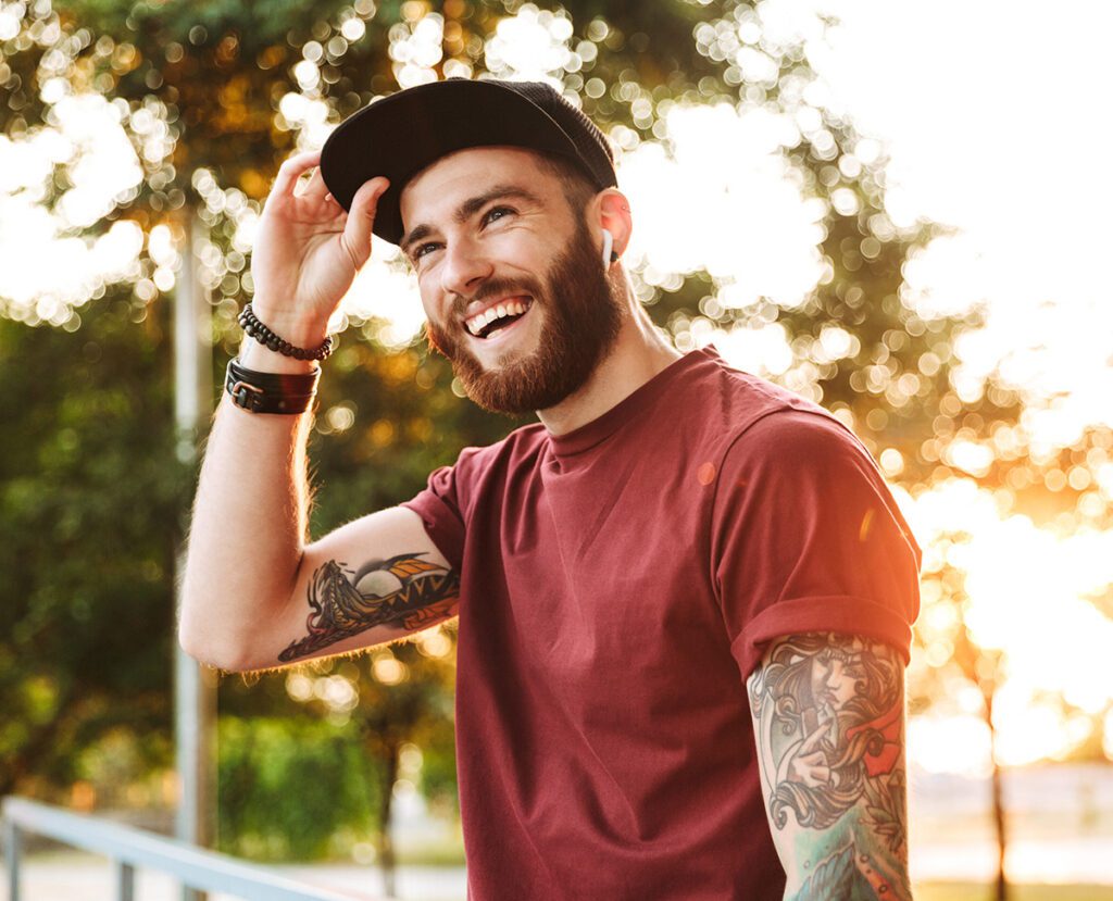 young man smiling while outside on a sunny day