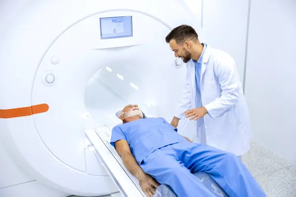 experienced radiologist encouraging senior patient mri scanning procedure hospital