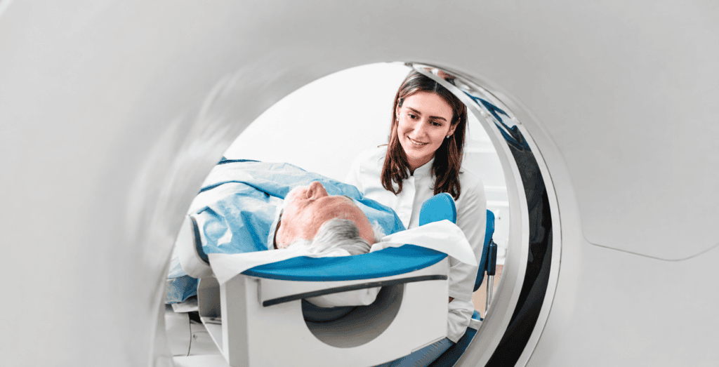 Radiologist helping patient while in a CT machine